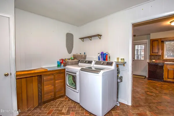 a kitchen that has a sink and a stove with wooden floor