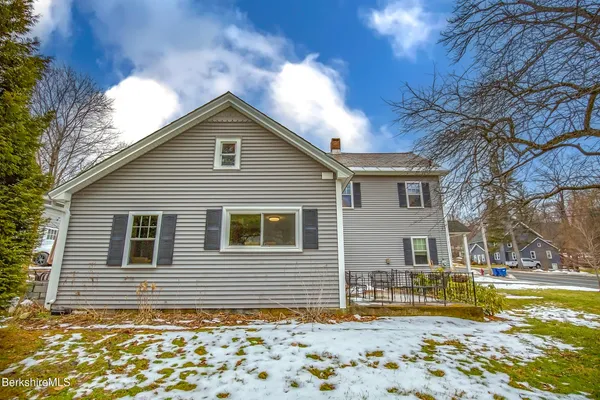 a front view of a house with a yard covered in snow