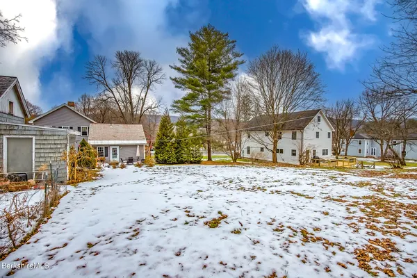 a front view of a house with a yard covered in snow