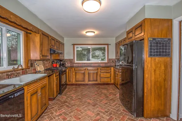 a kitchen with stainless steel appliances a sink cabinets and wooden floor