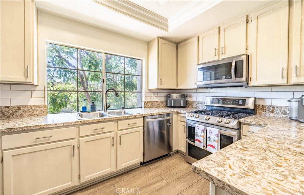 102 Vía Contento Rancho Santa Margarita, CA 92688 - Photo 2 of 40 a kitchen with cabinets appliances and a window