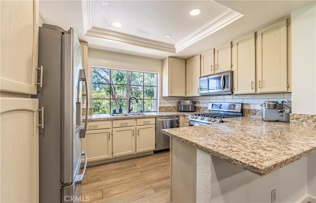 102 Vía Contento Rancho Santa Margarita, CA 92688 - Photo 3 of 40 a kitchen with a sink stove and cabinets