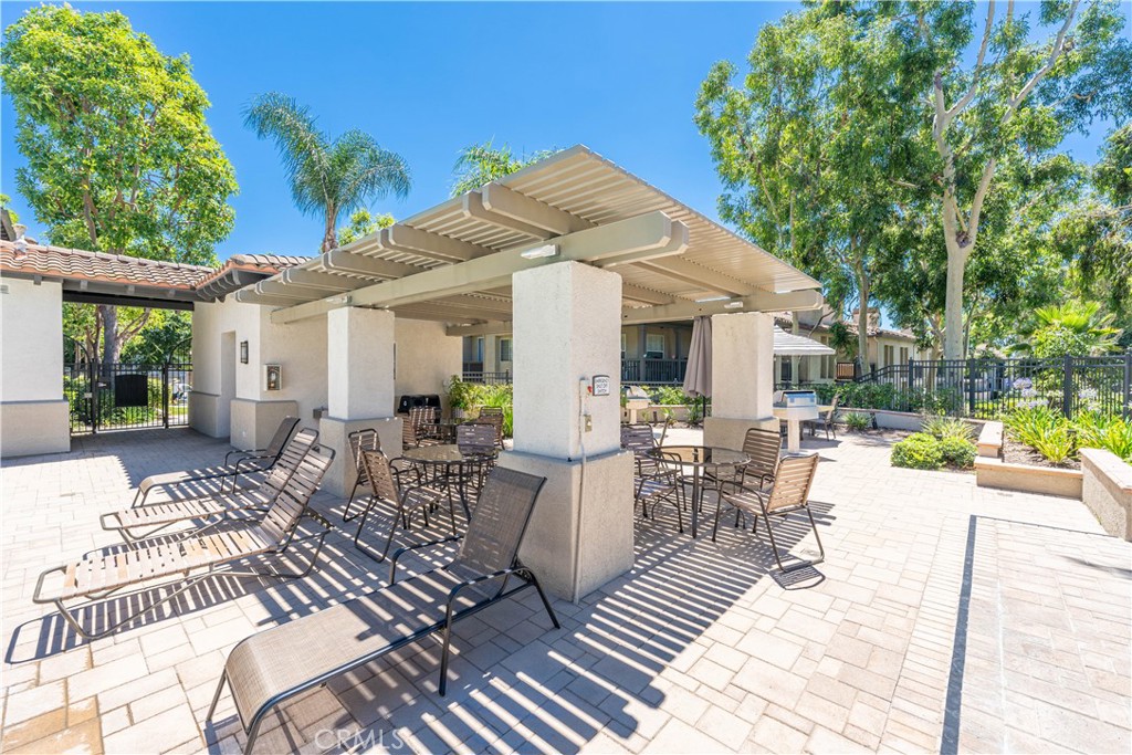 102 Vía Contento Rancho Santa Margarita, CA 92688 - Photo 40 of 40 a view of a patio with table and chairs and potted plants with wooden floor and fence
