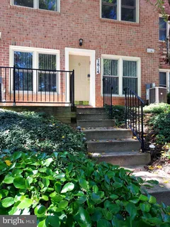 a view of a brick house with yard and plants