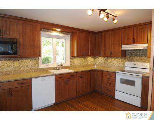 541 Georges Road Dayton, NJ 08810 - Photo 5 of 24 a kitchen with stainless steel appliances granite countertop a sink a stove a refrigerator cabinets and a window