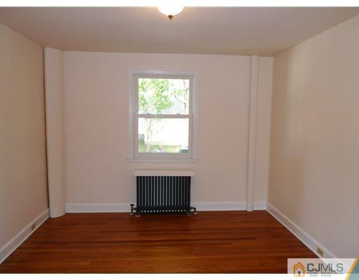 541 Georges Road Dayton, NJ 08810 - Photo 7 of 24 a view of an empty room with wooden floor and a window
