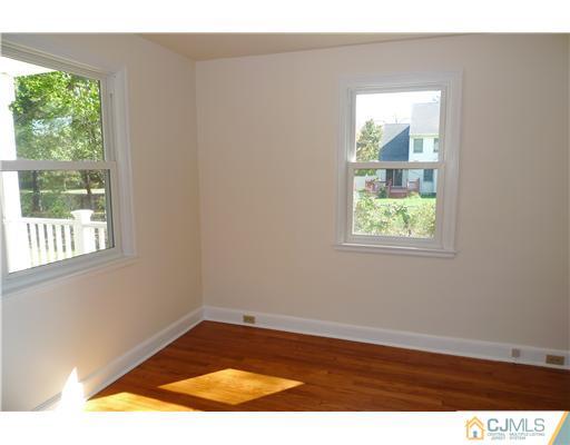 541 Georges Road Dayton, NJ 08810 - Photo 9 of 24 an empty room with wooden floor and windows