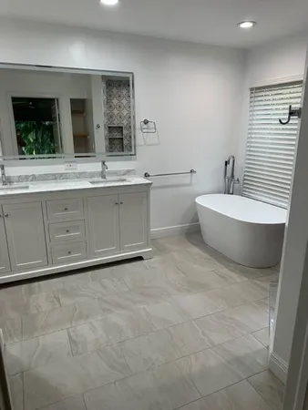 a spacious bathroom with a double vanity sink a mirror and a bathtub