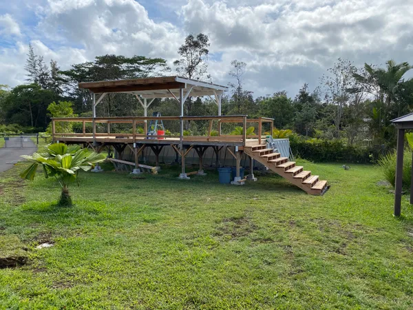 a view of a swimming pool and lounge chairs in back yard of the house