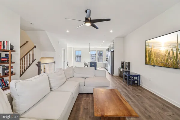 a living room with furniture and a ceiling fan