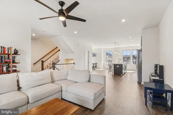 a living room with furniture kitchen view and a wooden floor