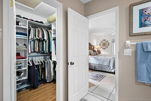 a view of walk in closet with clothes and shoes