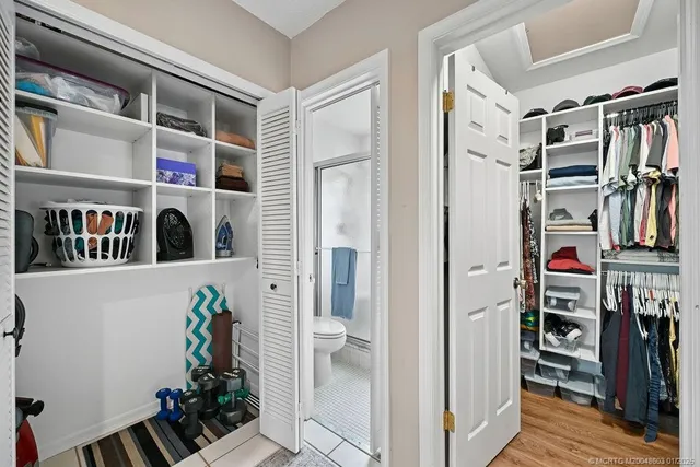 a view of walk in closet with clothes and shoes