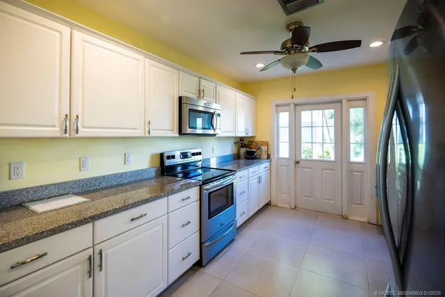 a kitchen with stainless steel appliances granite countertop a stove a sink and a refrigerator