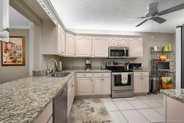 a kitchen with granite countertop cabinets stainless steel appliances and a counter space