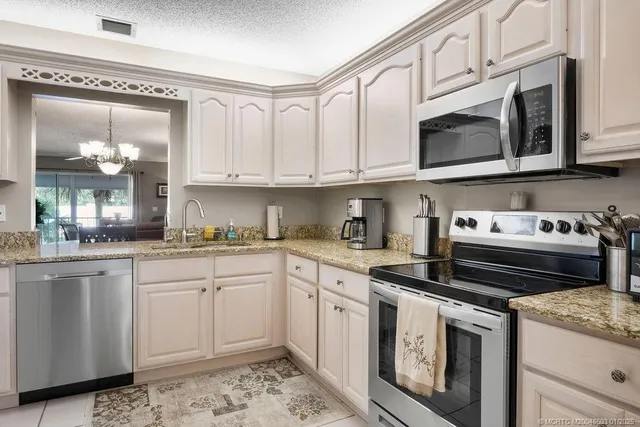 a kitchen with stainless steel appliances granite countertop a stove and white cabinets
