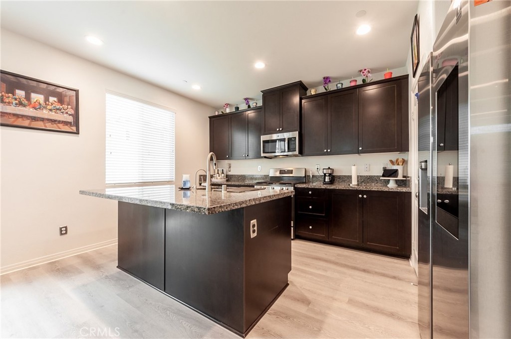 27283 Chase Road Menifee, CA 92584 - Photo 3 of 16 a kitchen with stainless steel appliances kitchen island granite countertop a refrigerator and a stove top oven
