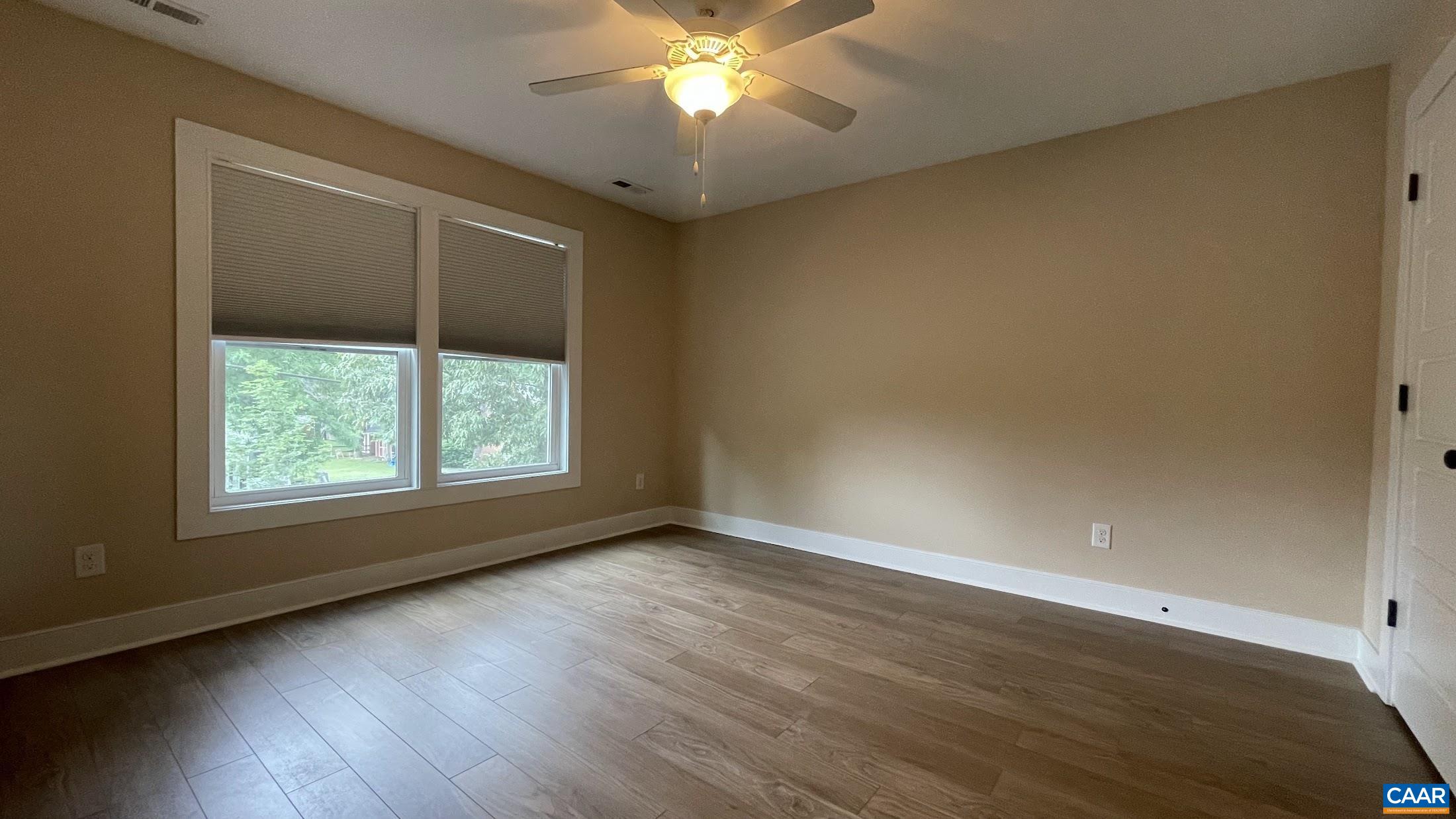 200 Harris Road Charlottesville, VA 22903 - Photo 19 of 28 an empty room with wooden floor chandelier fan and windows