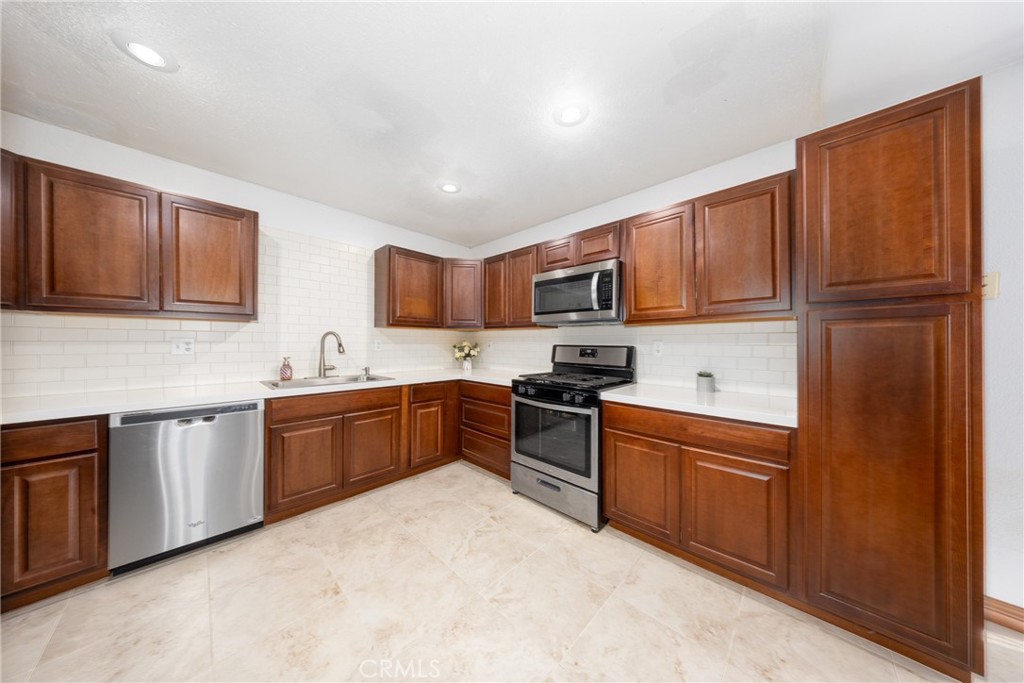 10514 Cameo Court Riverside, CA 92505 - Photo 13 of 30 a kitchen with stainless steel appliances granite countertop a refrigerator stove top oven and sink