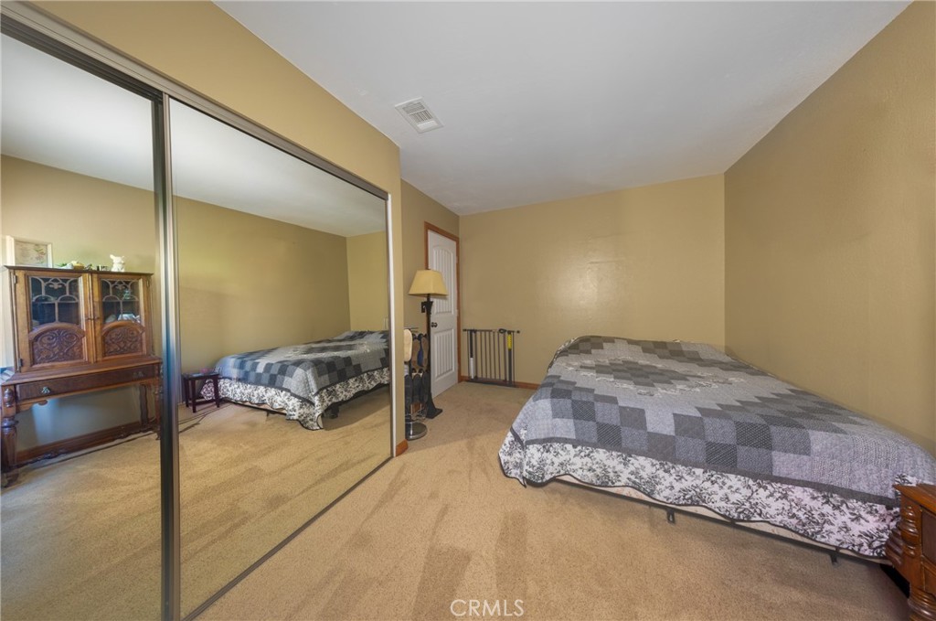 10514 Cameo Court Riverside, CA 92505 - Photo 17 of 30 a spacious bedroom with a bed and a table in it