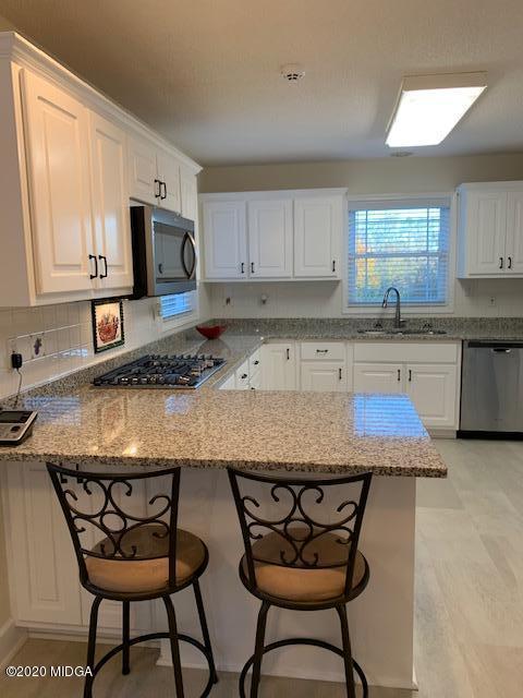 132 Brook Road Barnesville, GA 30204 - Photo 13 of 33 a kitchen with stainless steel appliances granite countertop a table chairs sink refrigerator and microwave