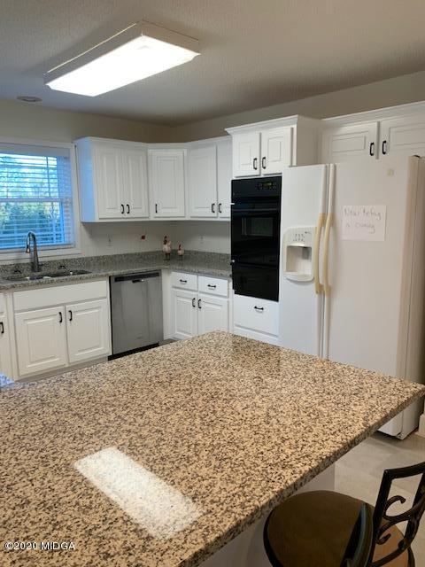 132 Brook Road Barnesville, GA 30204 - Photo 16 of 33 a kitchen with stainless steel appliances granite countertop a sink stove and refrigerator