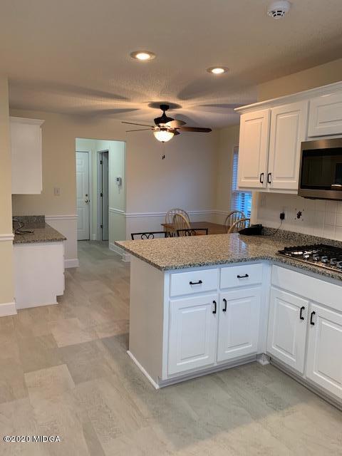 132 Brook Road Barnesville, GA 30204 - Photo 18 of 33 a kitchen with granite countertop a sink a stove top oven and cabinets