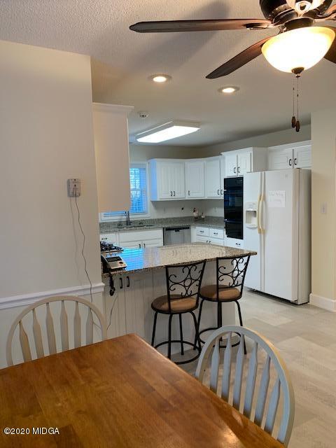 132 Brook Road Barnesville, GA 30204 - Photo 19 of 33 a kitchen with stainless steel appliances granite countertop a dining table chairs refrigerator and sink