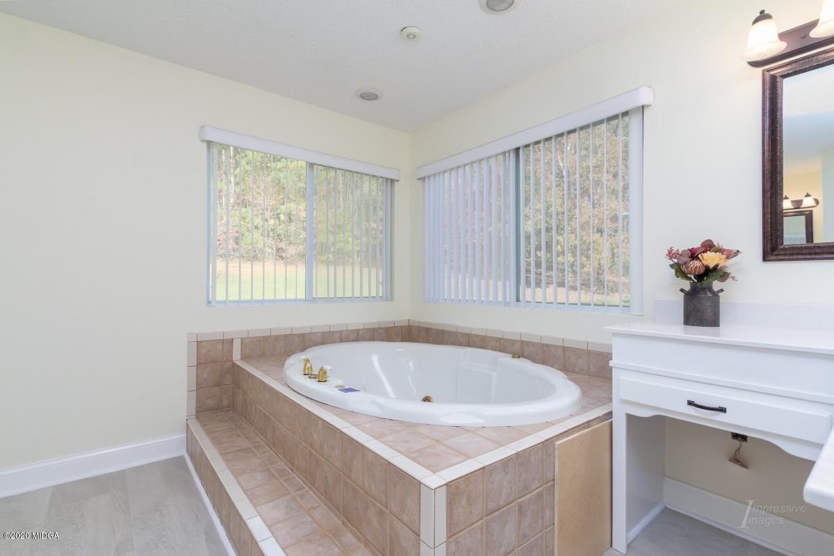 132 Brook Road Barnesville, GA 30204 - Photo 22 of 33 a white bath tub sitting in a bathroom next to a window