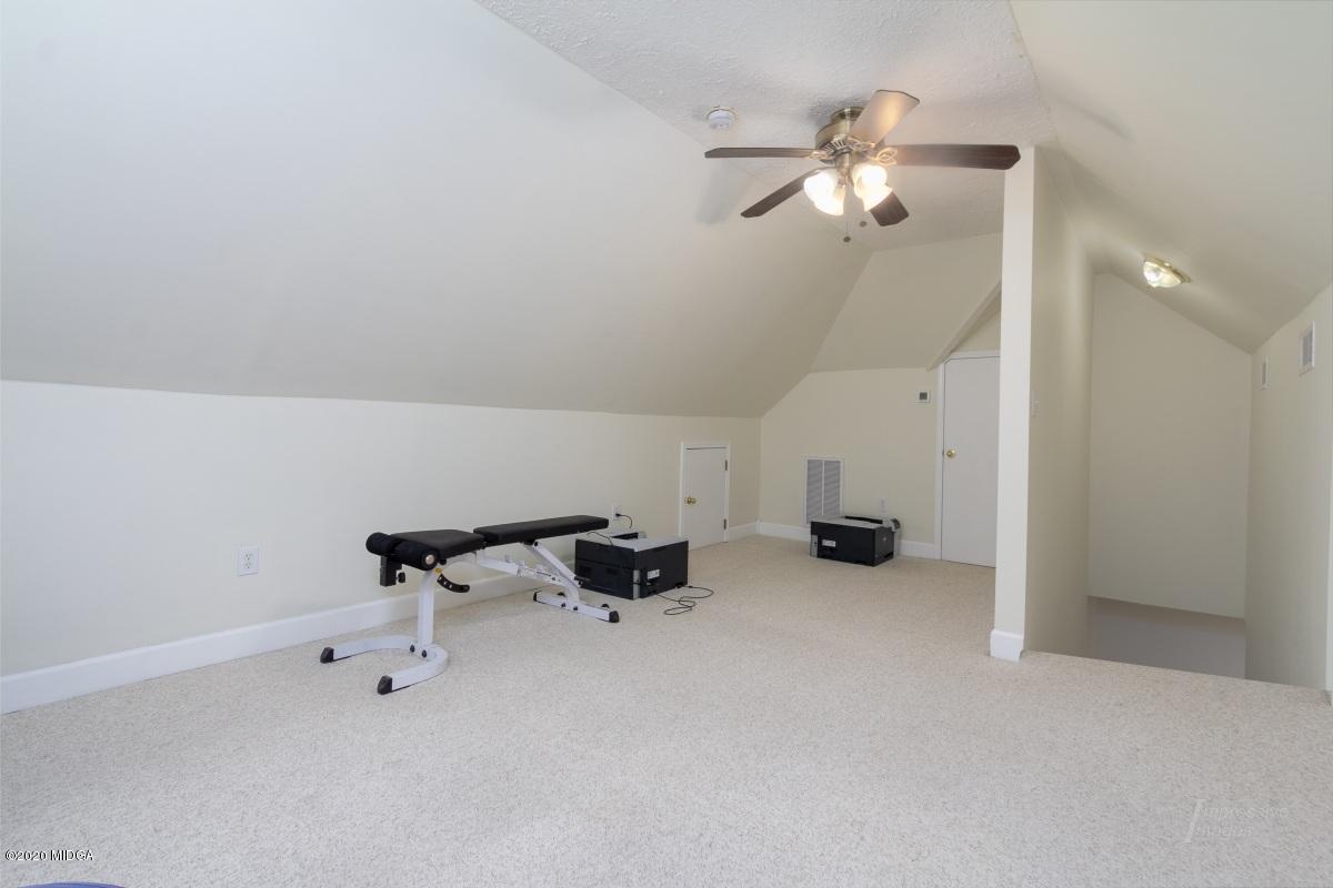 132 Brook Road Barnesville, GA 30204 - Photo 30 of 33 an empty room with a chandelier fan and wooden floor