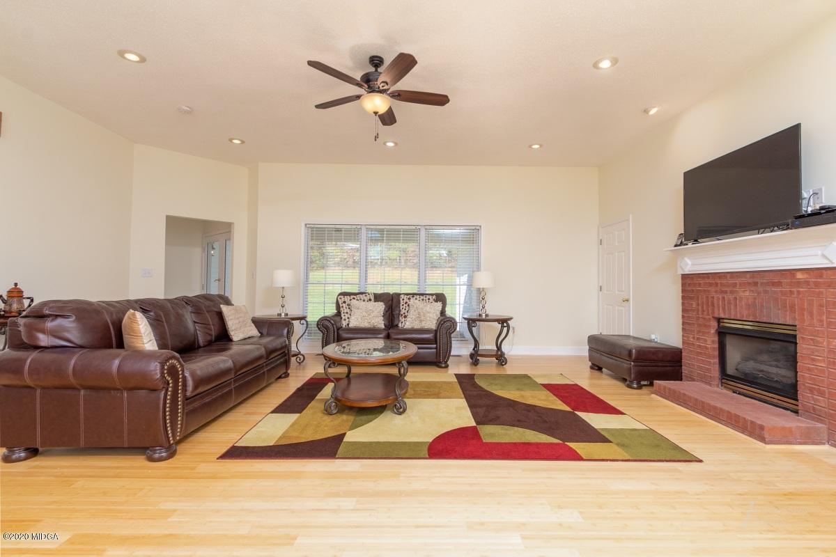 132 Brook Road Barnesville, GA 30204 - Photo 6 of 33 a living room with furniture a flat screen tv and a fireplace