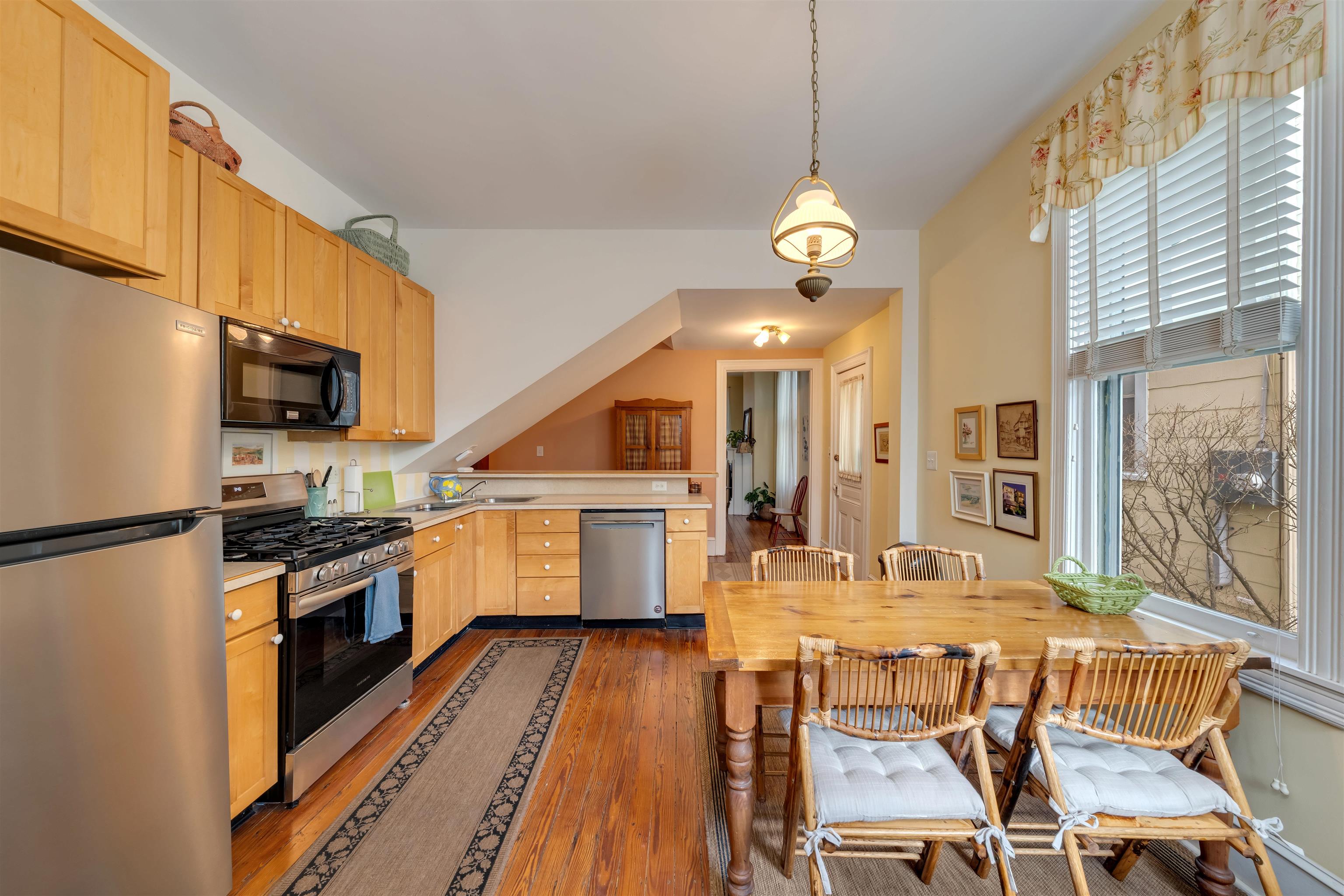 130 Decatur Street Cape May, NJ 08204 - Photo 17 of 50 a kitchen with stainless steel appliances granite countertop a refrigerator a stove top oven a sink dishwasher a dining table and chairs with wooden floor