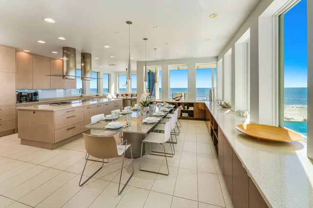 a view of a kitchen with kitchen island a large window a sink and a counter