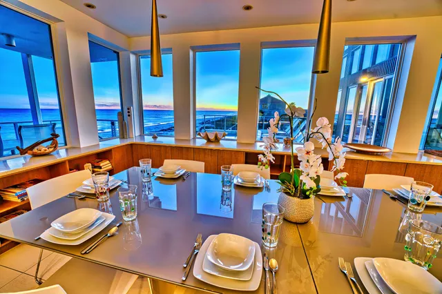 a living room with couches a fireplace and four windows