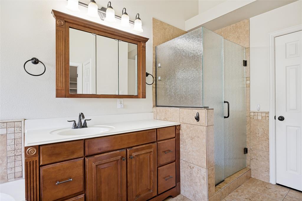 2100 Los Rios Boulevard Plano, TX 75074 - Photo 16 of 25 Bathroom featuring a wood-finish vanity with a single sink and white countertop
