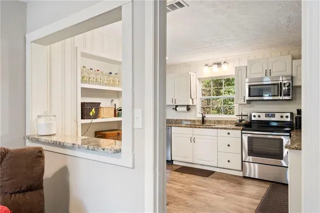 a kitchen with stainless steel appliances granite countertop a stove and cabinets
