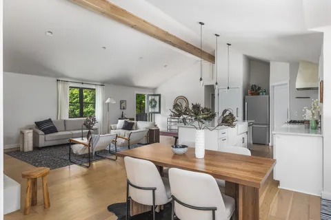 a living room with furniture kitchen view and a large window