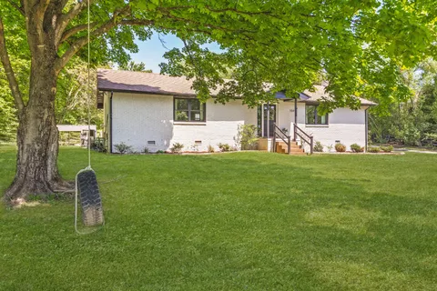 a view of a house with a yard and a tree