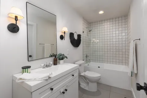 a bathroom with a granite countertop sink a toilet and a mirror