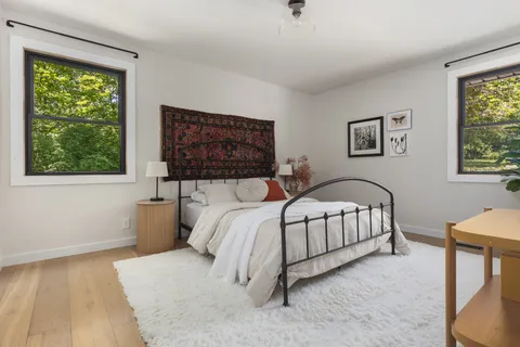 a bed sitting in a bedroom next to a window