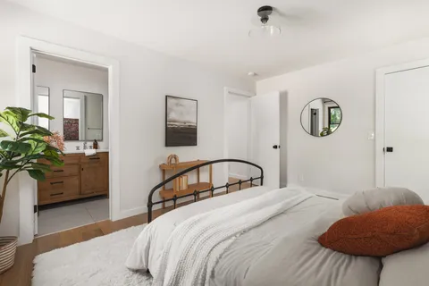 a bedroom with a bed a couch and a potted plant