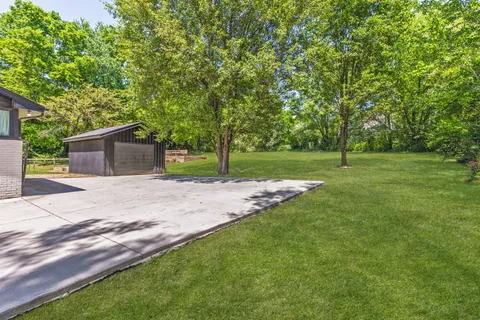 a view of a house with a yard and tree s