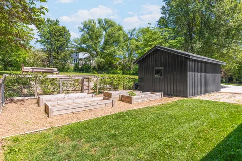 a view of a backyard with a garden and outdoor seating