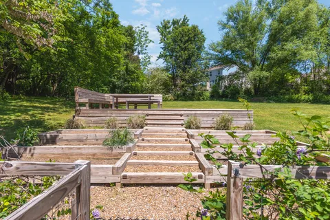 a view of a patio with chairs and a table with potted plants