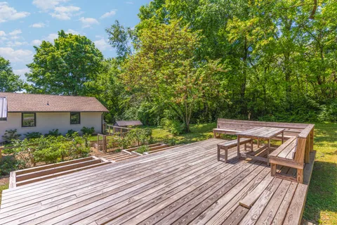 a view of house with wooden deck and furniture