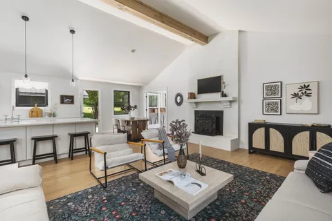 a living room with furniture a flat screen tv and a fireplace
