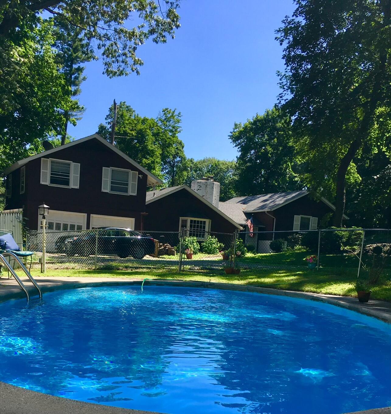 25 Goodwives River Road Darien, CT 06820 - Photo 15 of 17 a view of a swimming pool with lawn chairs under an umbrella