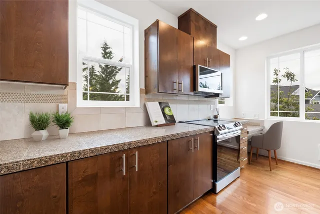 a kitchen with stainless steel appliances granite countertop a stove a sink and a refrigerator