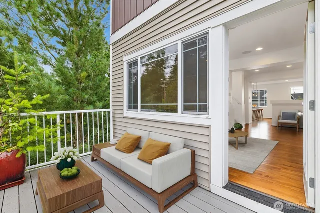 a view of a deck with couches table and chairs with wooden floor and fence
