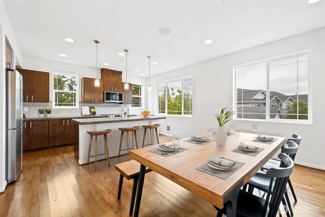 a kitchen with kitchen island a dining table and chairs